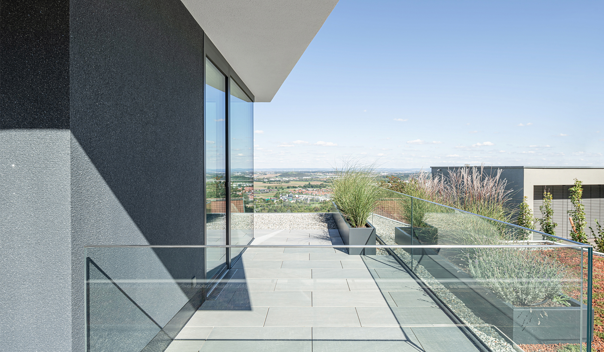 Bild 6 Villa in Gerlingen Dachterrasse mit Fernblick gerahmt von Glasbruestung Zierkies und Pflanzbeet